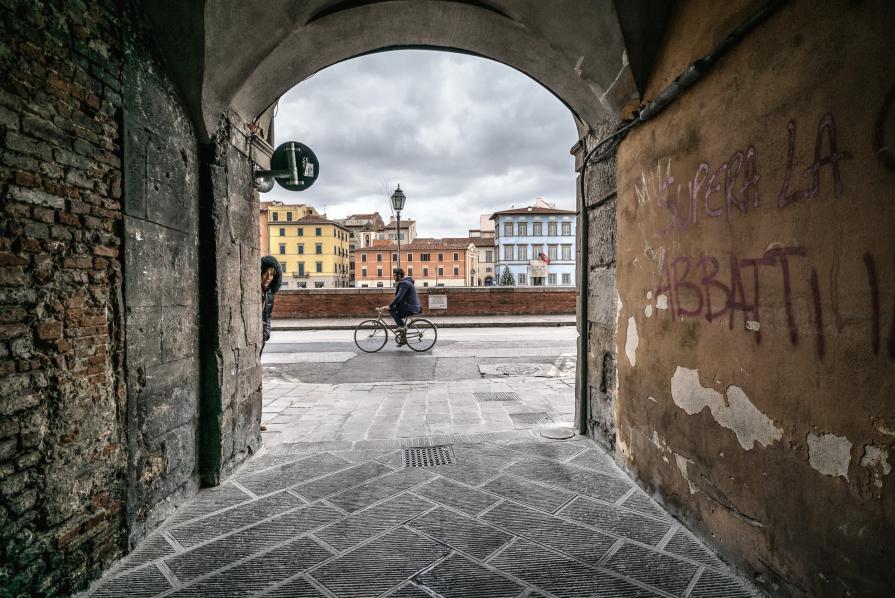 Capriccio con donna incappucciata, ciclista e Palazzo Blu sul Lungarno Pacinotti