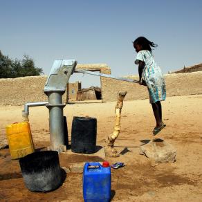 Bambina sospesa alla pompa dell'acqua