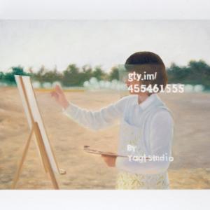 A Contemporary Portrait of the Internet Artist - Woman drawing the oil painting on the beach